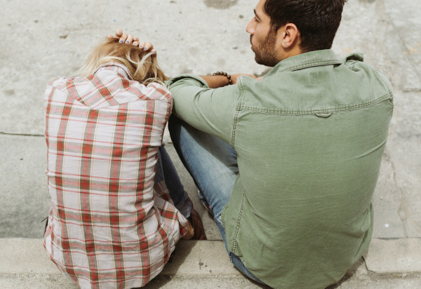 A guy sitting next a girl who is looking overwhelmed