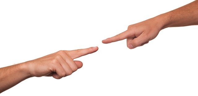 Two hands pointing at each other