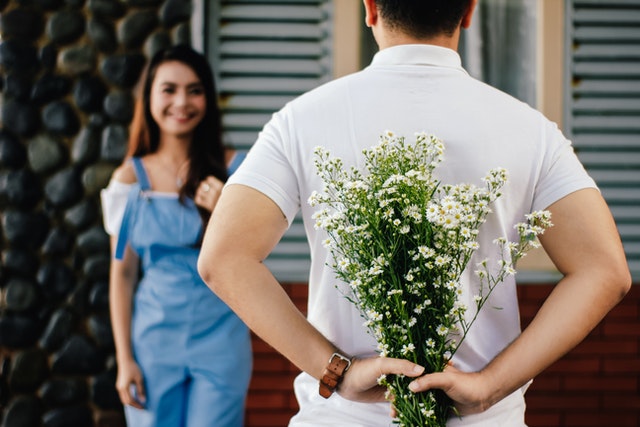 A boy giving a girl flowers