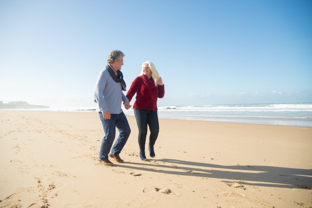 A couple walking and talking on a beach
