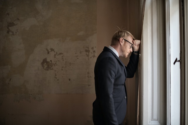 A middle-aged man looking out of a window