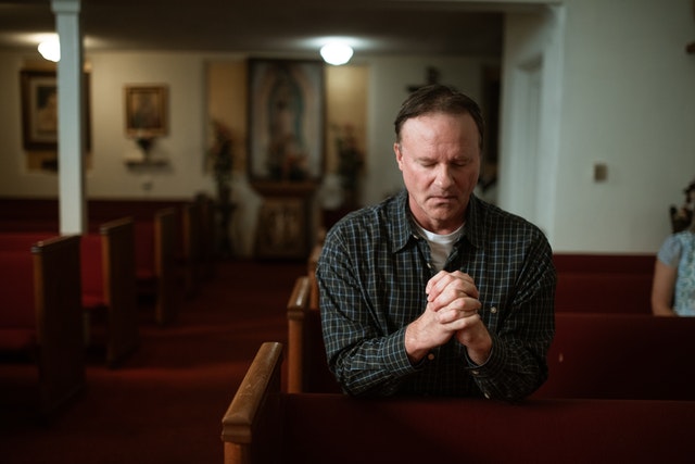 A man praying in a church.