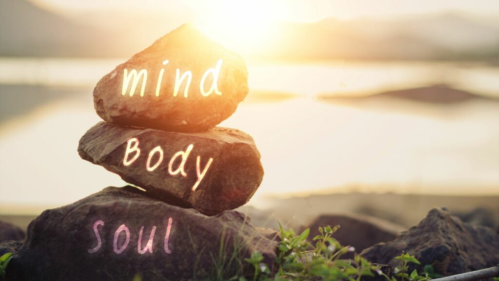 Rocks with Mind, body, soul stacked against sun rise